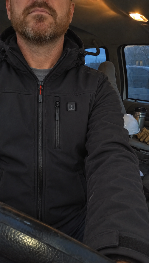 Gros plan sur la veste chauffante noire et son bouton de chauffage